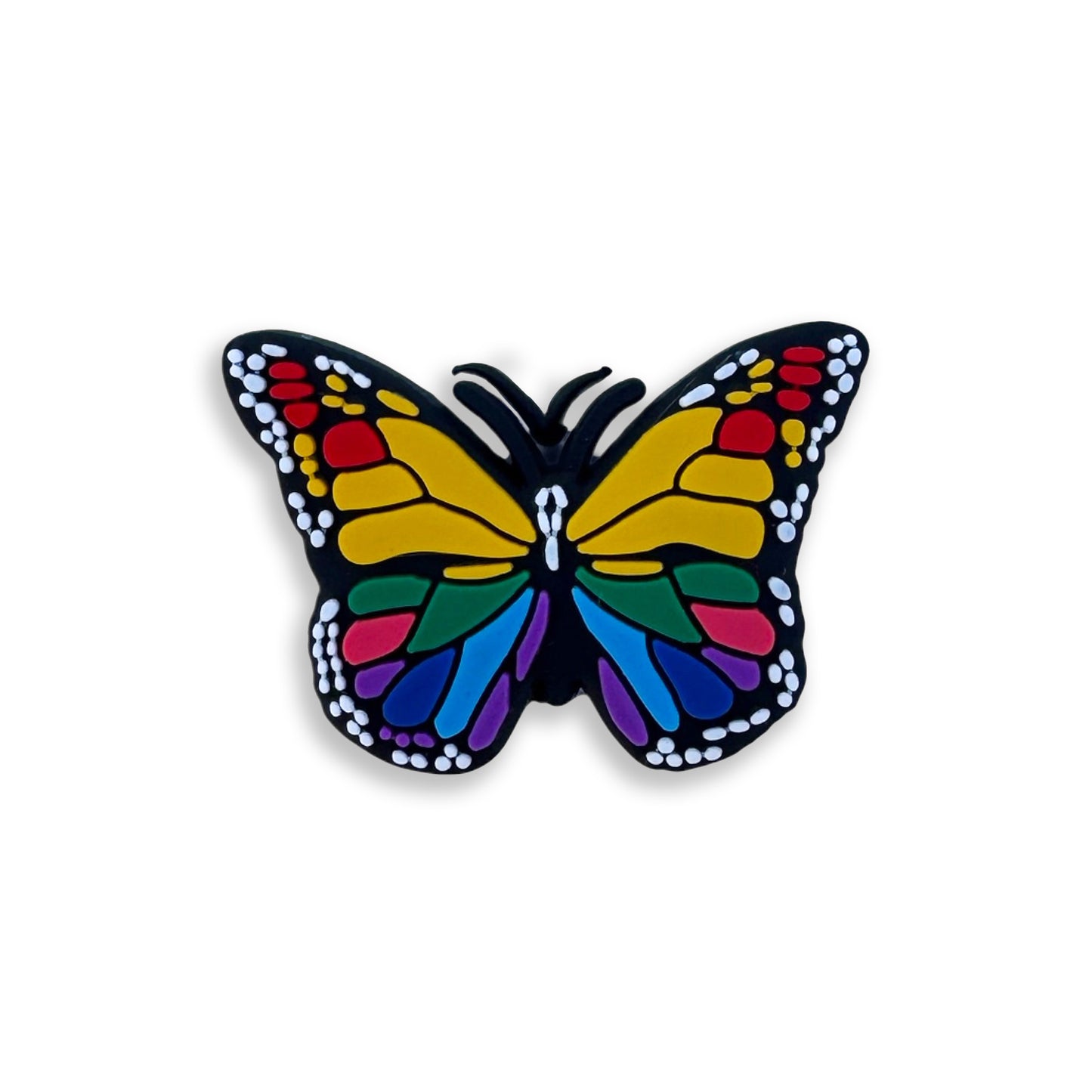 Colorful butterfly charm designed for clogs. Features vibrant yellow, red, blue, and green patterns on a black background.