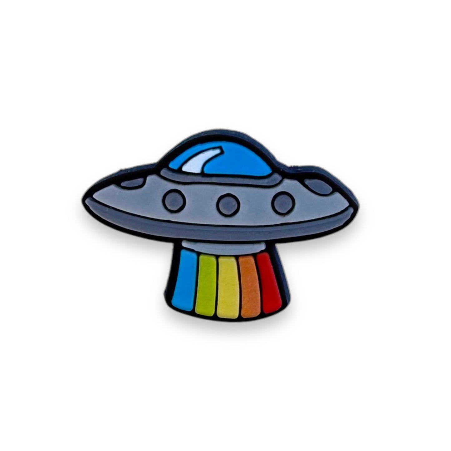 Clog charm of a U F O saucer-shaped space ship with five vertical blasts of color extending below it.