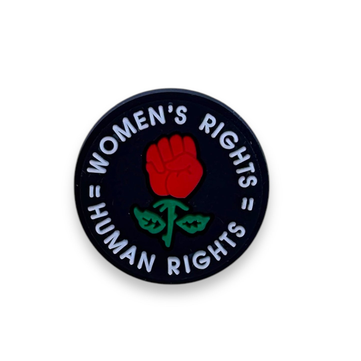 Black circle clog charm with a red rose in the shape of a fist encircled by the words: Women's Rights equals Human Rights.