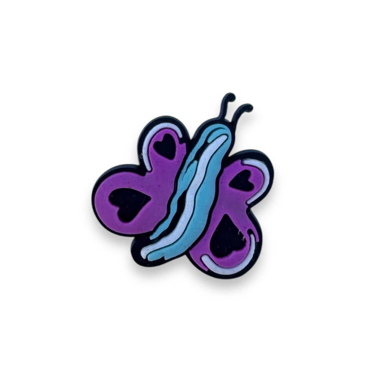 Butterfly clog charm with a blue body and two black hearts on each purple wing.