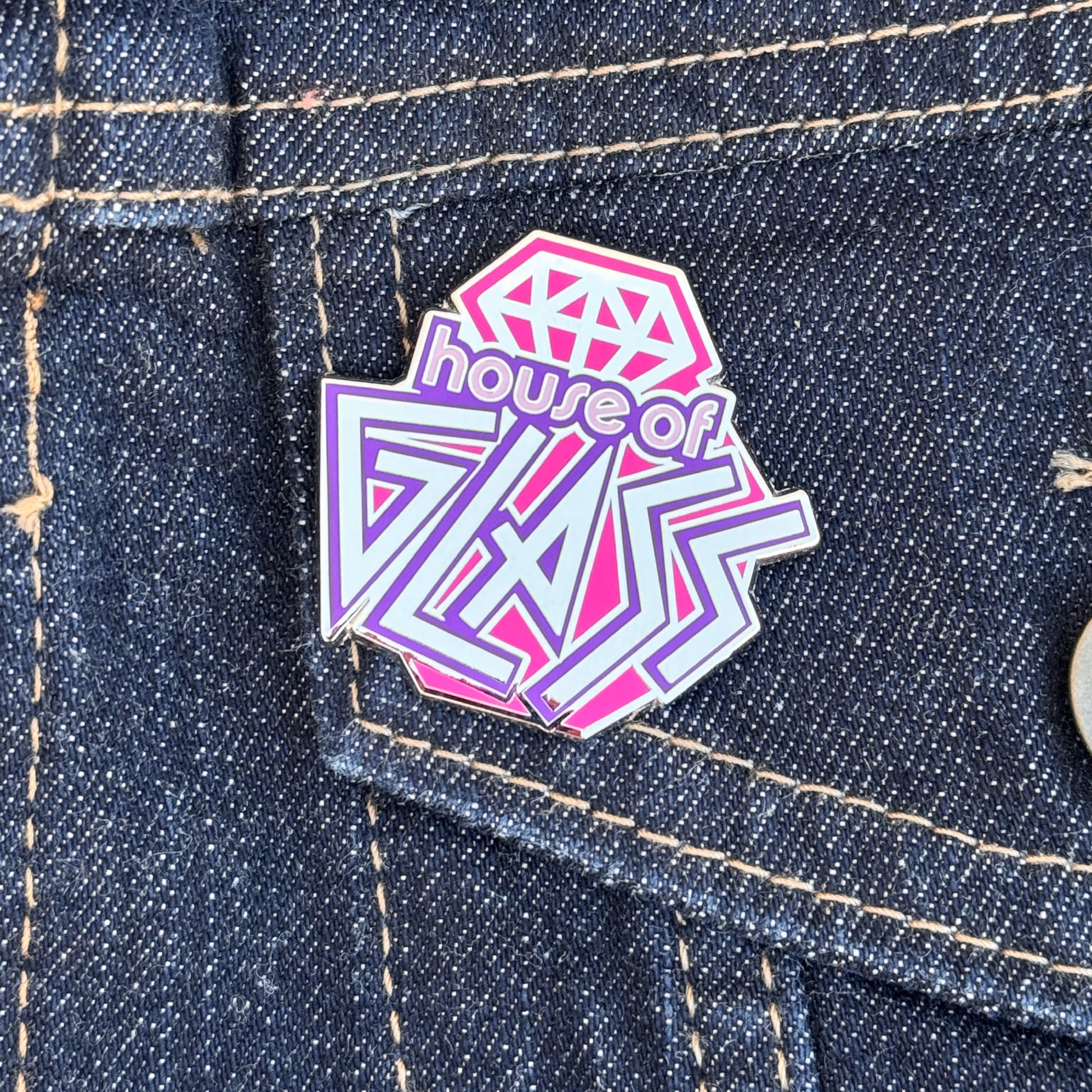 Pink and purple House of Glass logo pin.