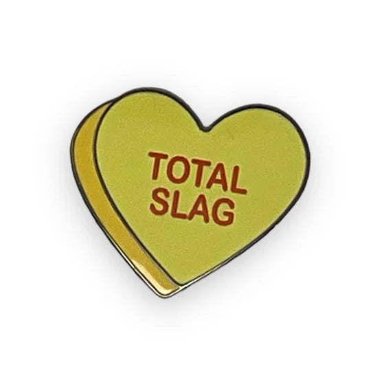 Yellow heart-shaped pin with the words: TOTAL SLAG.