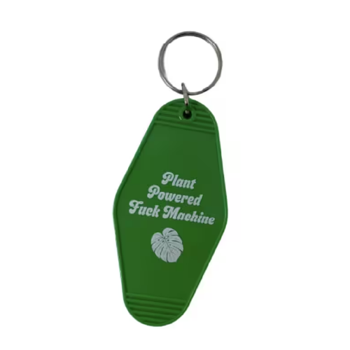 Green vintage motel keychain with fully spelled out words: Plant Powered F U C K Machine, and a leaf icon.