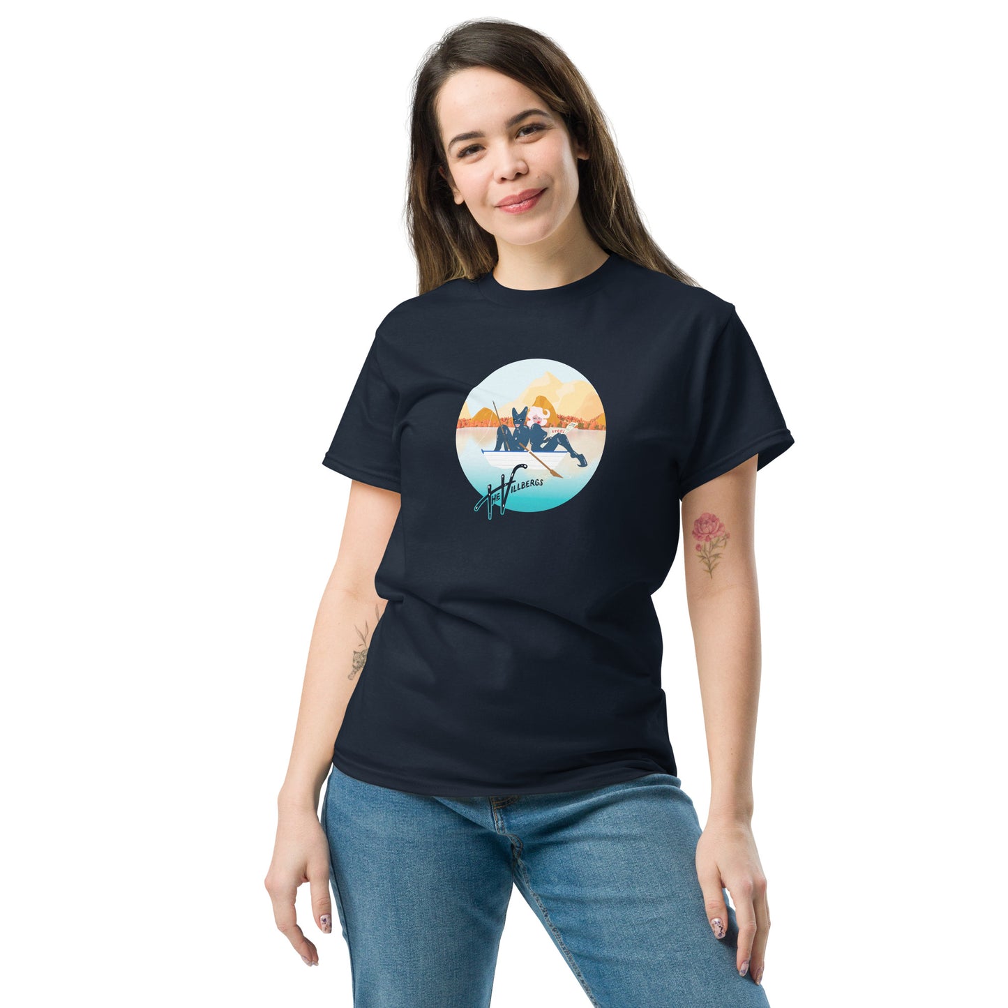 Female model in Navy tee with cartoon of the Villbergs in a row boat, inside a circle, with The Villbergs wordmark.