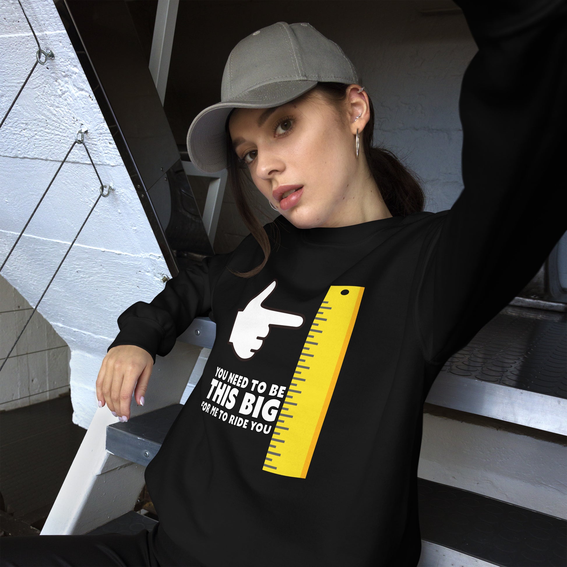 Female in black sweatshirt: You need to be this big for me to ride you, under a cartoon hand pointing at a large ruler.
