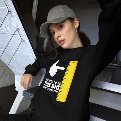 Female in black sweatshirt: You need to be this big for me to ride you, under a cartoon hand pointing at a large ruler.