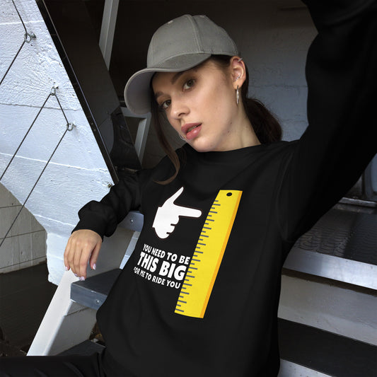 Female in black sweatshirt: You need to be this big for me to ride you, under a cartoon hand pointing at a large ruler.