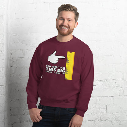 Man in maroon shirt. You need to be this big for me to ride you, with cartoon hand pointing at the vertical yellow ruler.