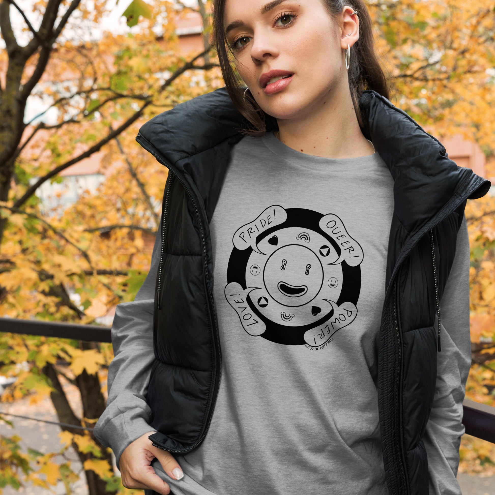 Woman models an athletic heather shirt with the smiley face graphic with speech bubbles: Pride, Queer, Power and Love.