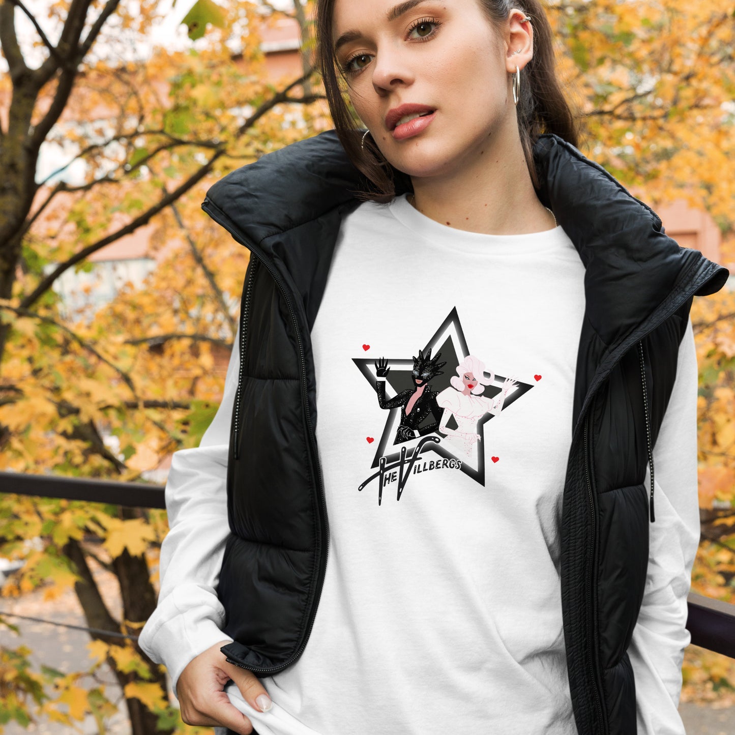 White shirt with black and white star and cartoon of the Villbergs inside it. With 4 small red hearts and Villbergs logo.